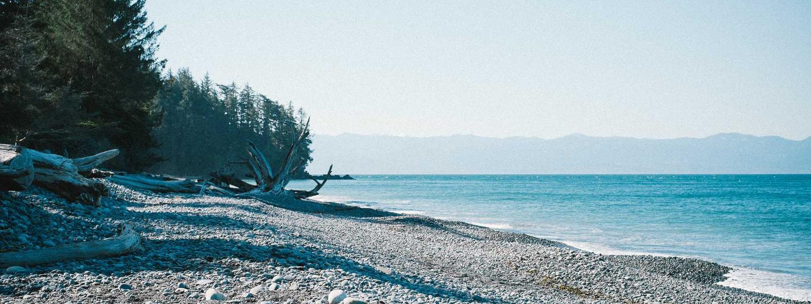 Pebble beach and ocean with mountains in the background