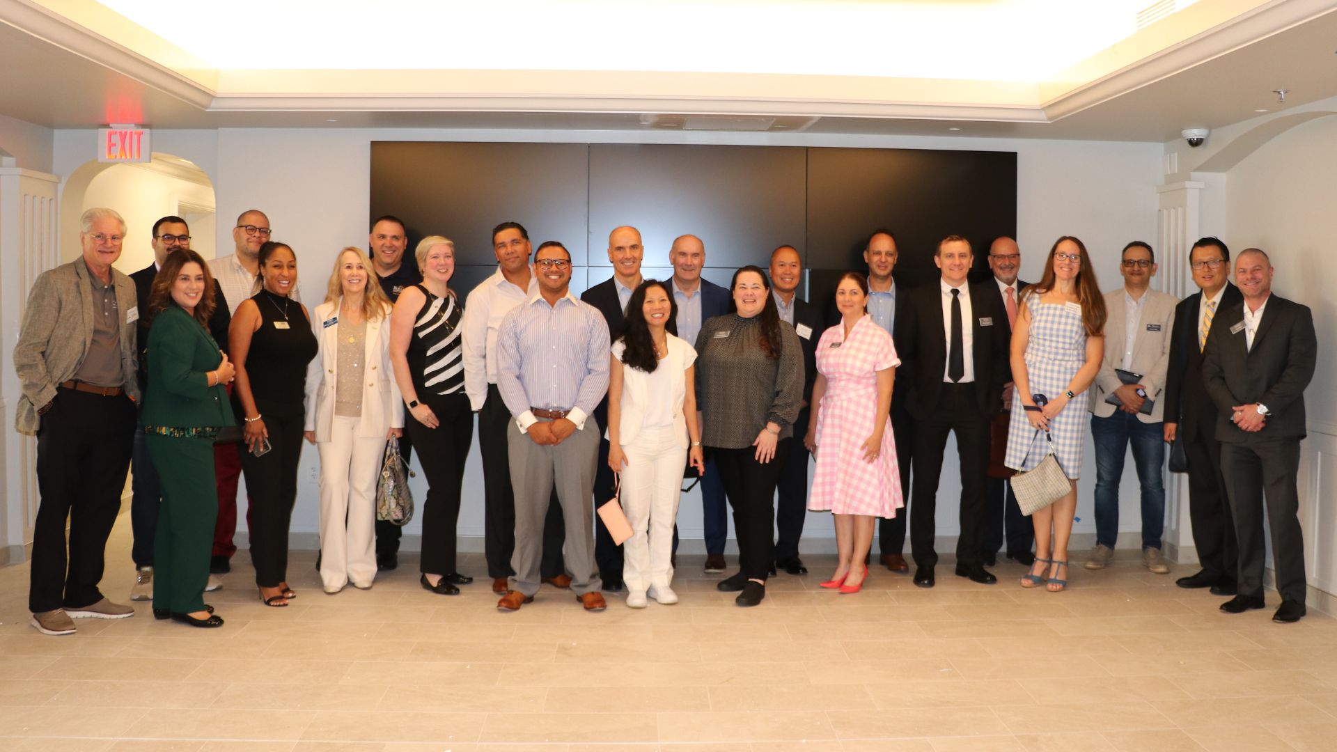 group of twenty EDBA alumni stand in refreshed Crummer lobby