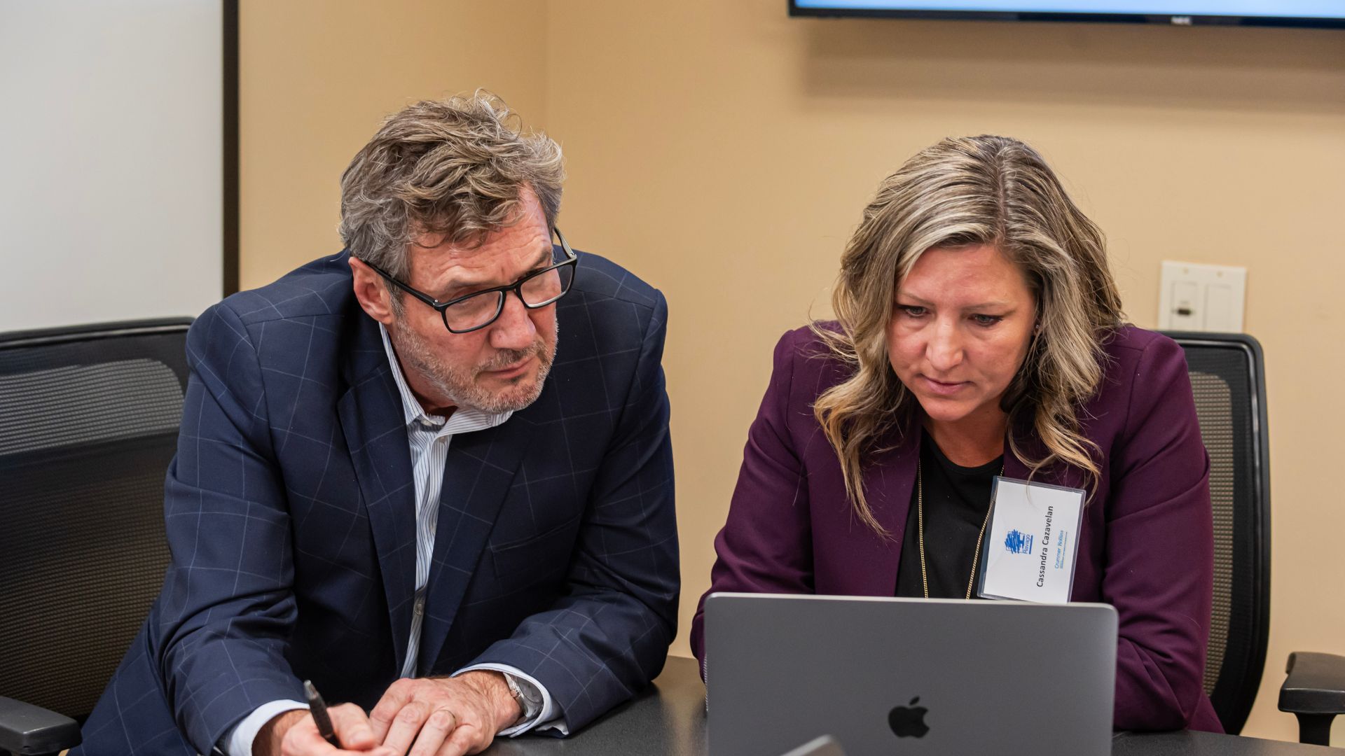 man and woman looking intently at laptop screen